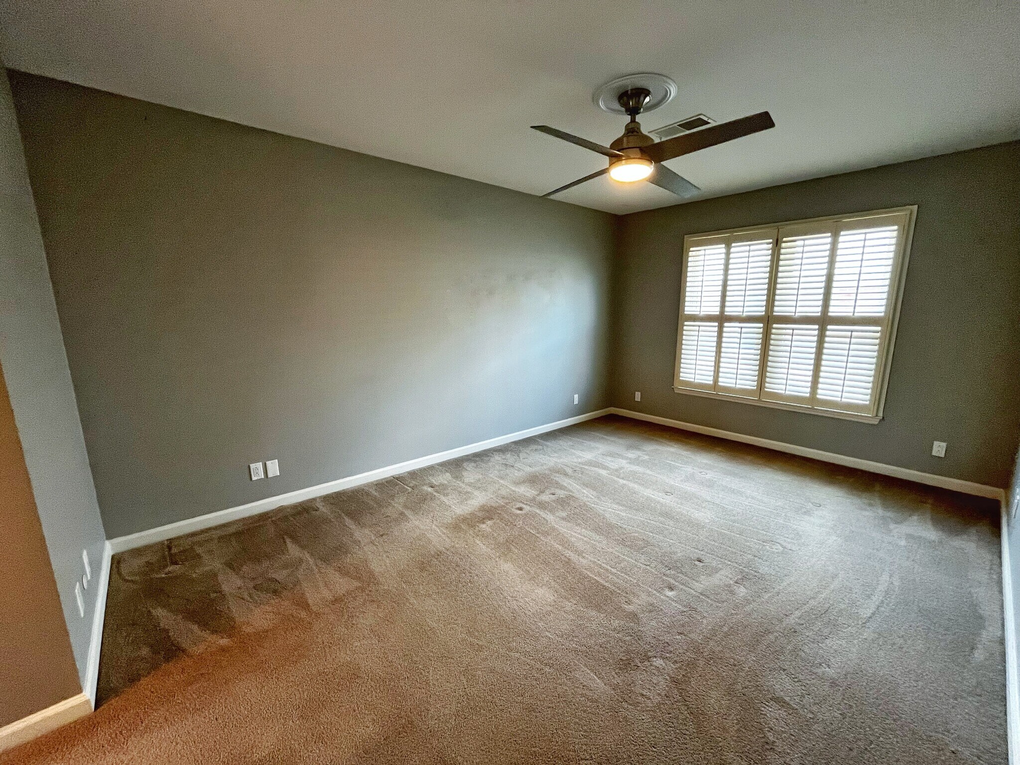 Primary bedroom with custom plantation blinds and two walk-in closets! - 604 Sherbourne Grn