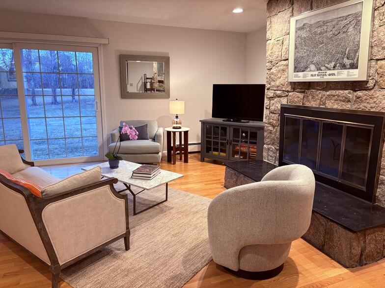 Living room features a Stony Creek granite fireplace, comfortable furniture, TV with Roku, and board - 683 Richies Way