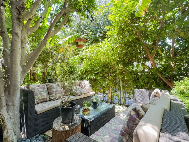Serene garden with tropical fruit trees, water feature and ample seating. - 12063 Lamanda St