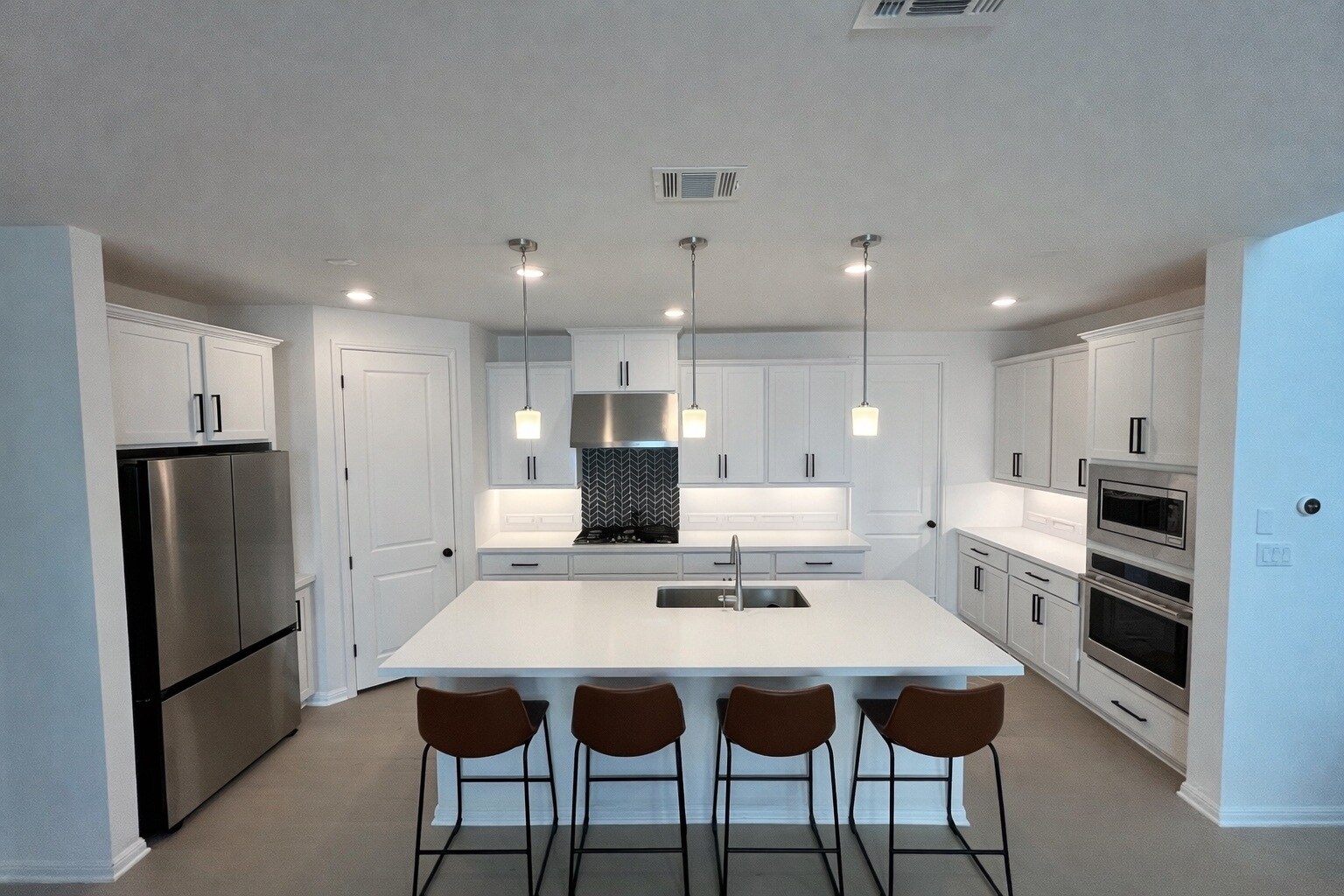 Spacious modern kitchen with large island, 5-burner gas cooktop, and stainless steel appliances. - 517 Moonlit Stream Pass