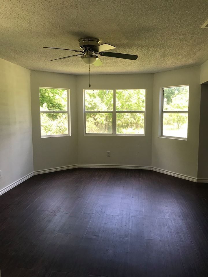 Freshly painted living room with new ceiling fan and wood-look vinyl flooring. - 838 Lizzie Ln