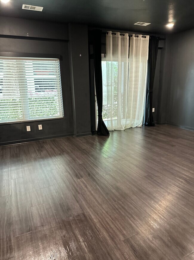 Open Living room and sliding glass doors to patio. - 4361 S Congress Ave