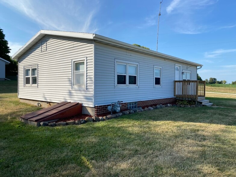 Side of house with basement access. Some shelving down there and room for storage. - W4493 Spruce Dr