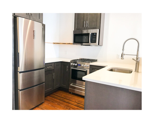 Above fridge and microwave storage ceiling-height cabinets. 4 burner gas stove/oven. GE refrigerator and microwave. Industrial goose neck sink faucet. Dishwasher to the right of sink (not pictured). This photo was taken before we added the floating shelves next to the microwave. - 18 W State St