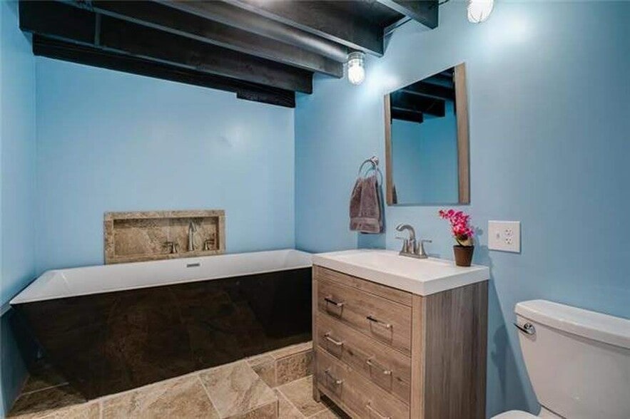 Downstairs full bath with large tub, and full stand-in shower. Vanity and storage closet. - 7416 N. Central St.