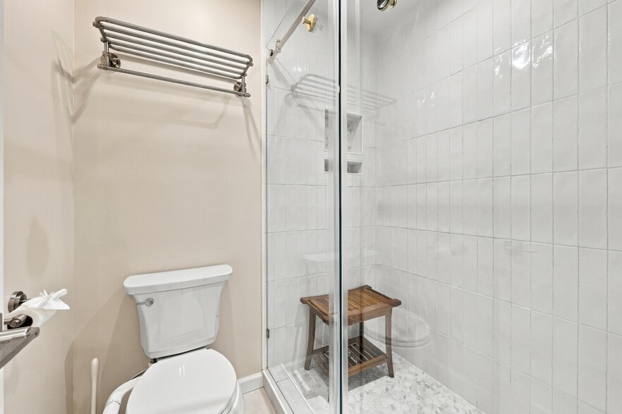 Updated primary bath features a glass-enclosed tiled shower. - 3622 Caroline Vale Blvd