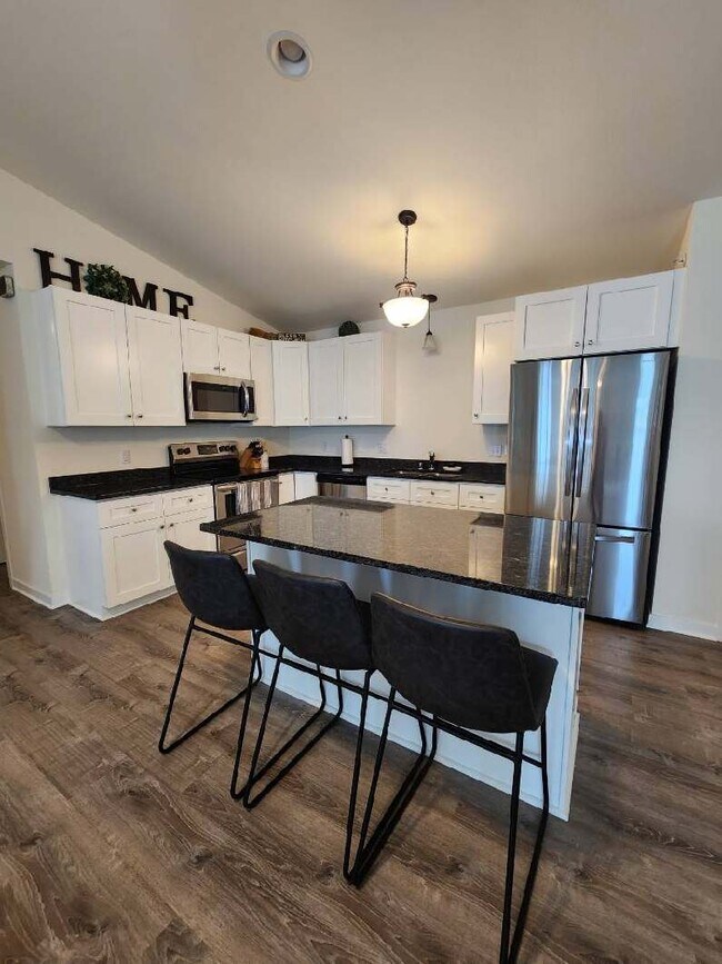 Kitchen with island. Fridge, microwave, oven, dishwasher, washer & dryer included in unit - Trail View Village Apartments