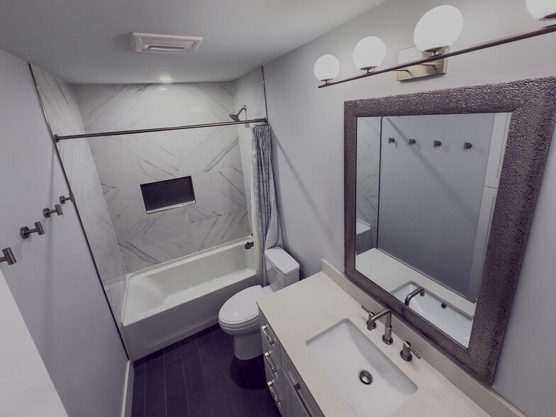 Bathroom with marble tile shower, quartz countertop vanity, and modern fixtures - 2006 Candle Ct