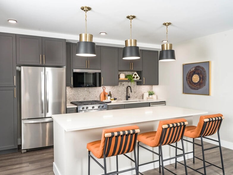 Modern kitchens feature sleek cabinetry, quartz countertops, and stainless steel appliances with designer pendant lighting. - Modera Reserve