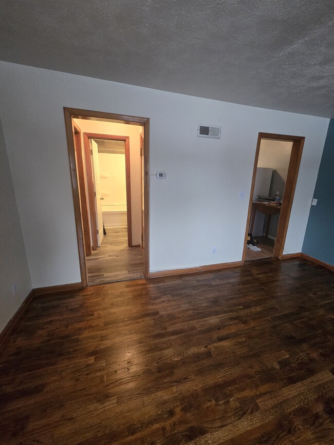 Living room with doors to kitchen and hallway/ bedroom bathroom - 613 W 25th St