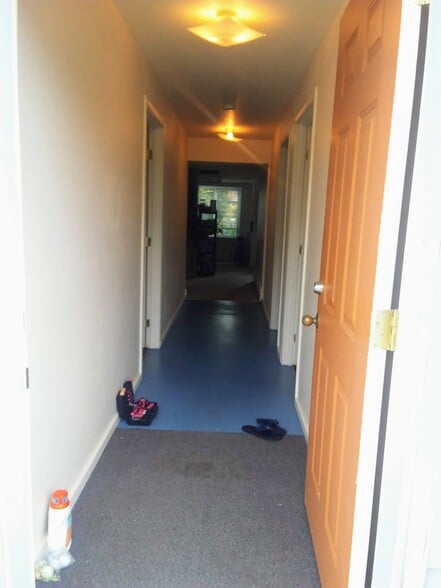 View from backdoor into the bedroom hallway. Two bedrooms are on the right and one on the left. The bathrooms the next door on the left. The kitchen and living room are seen at the far end of the photo - 2909 NW Fillmore Ave