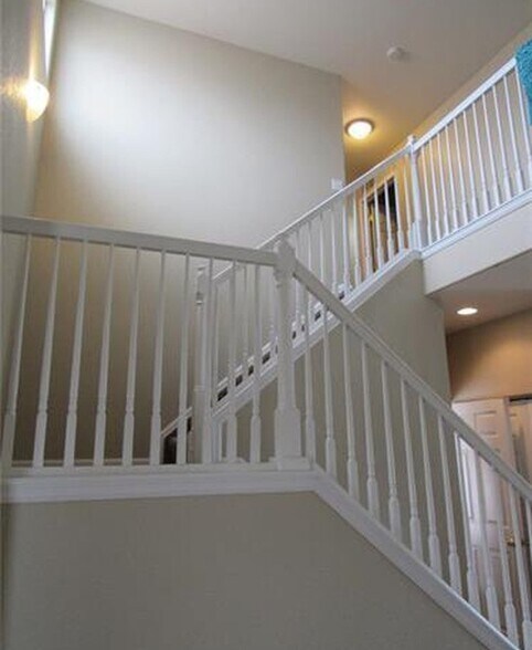 Staircase leading to upper level bedrooms and bath. - 7334 Pearly Heath Rd