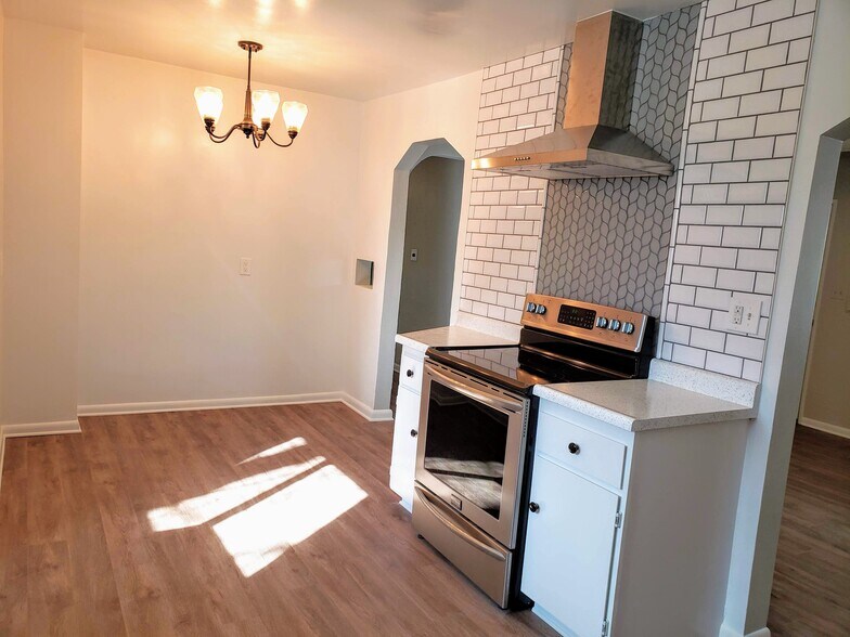 Eat in kitchen with continuous luxury vinyl plank flooring, SS appliances, and gorgeous tile back-splash. - 3155 S Fox St