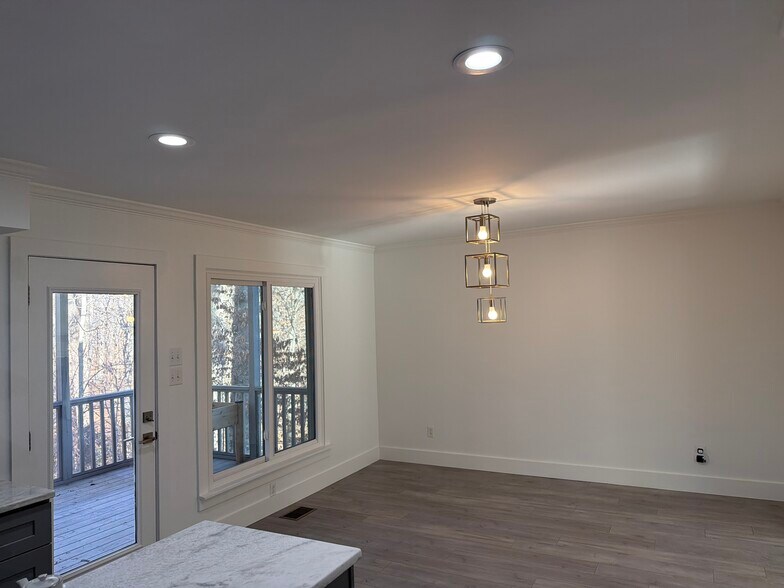 Open kitchen to dining room with great views out through screened-in porch to natural back yard. - 115 Waterfall Ct