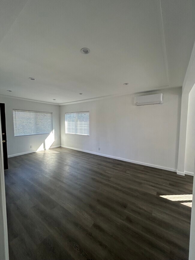 living room area w/2 large windows & AC pictured - 1425 Hauser Blvd