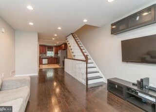 65" TV hung and ready for you to watch movies. Included are built-in shelving and tv stand, so no need to buy additional furniture for entertaining. - 2030 McClellan St