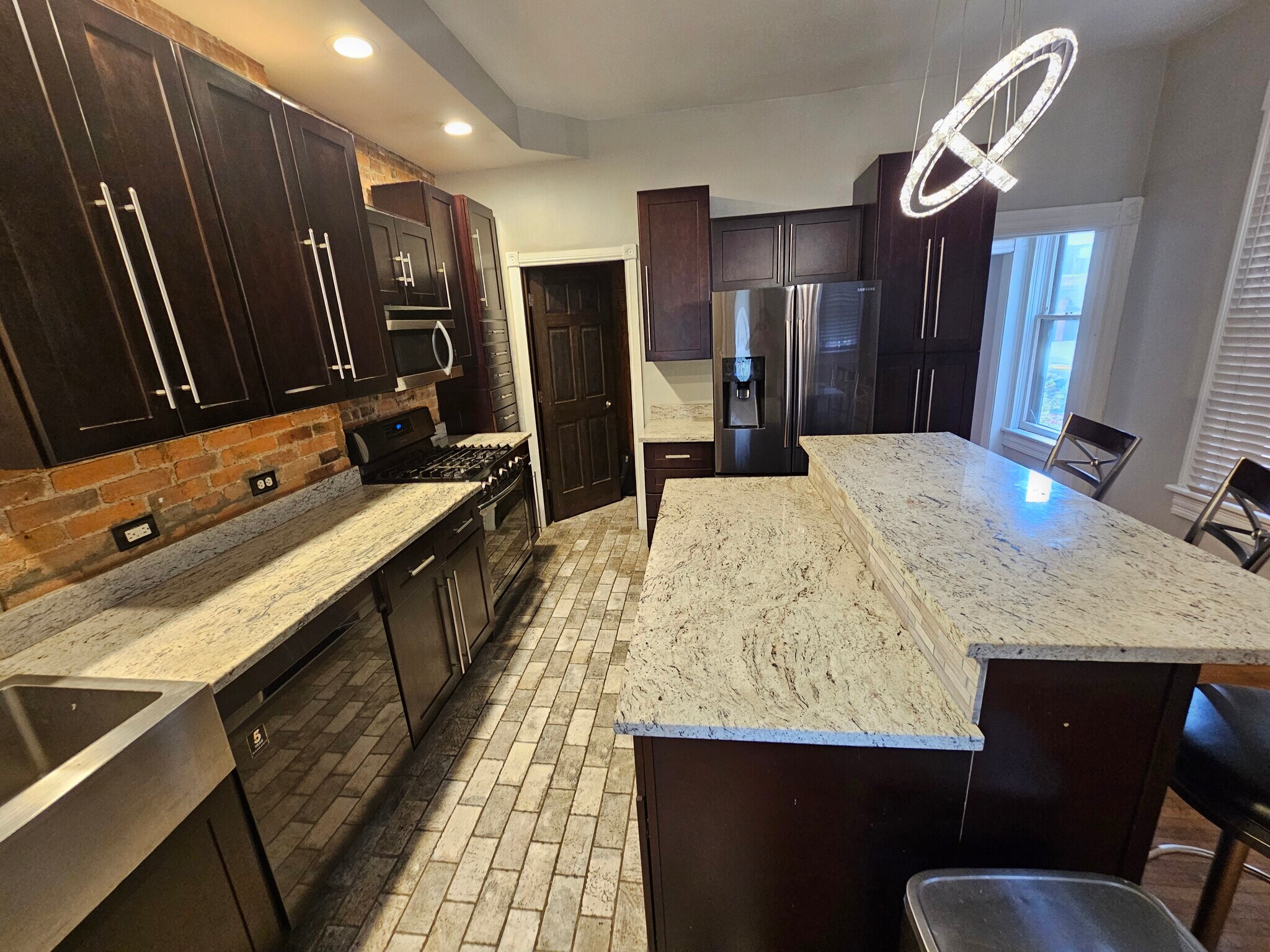 Some exposed brick/modern stainless steel appliances and New York Brick tile. - 943 Highland St