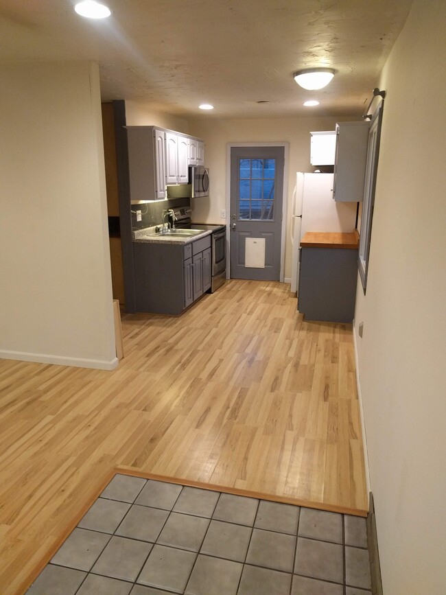 Galley kitchen with washer, dryer, and pantry to the left. Door goes to large fenced backyard. - 4225 Sheffield Road