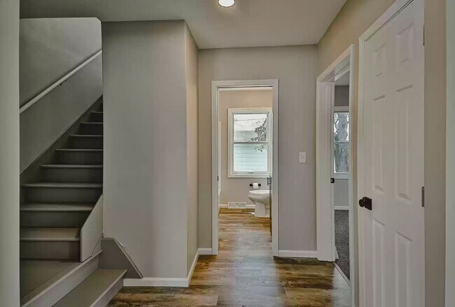 hall going to upper level, bath, and primary bed room - 743 Marie Ave