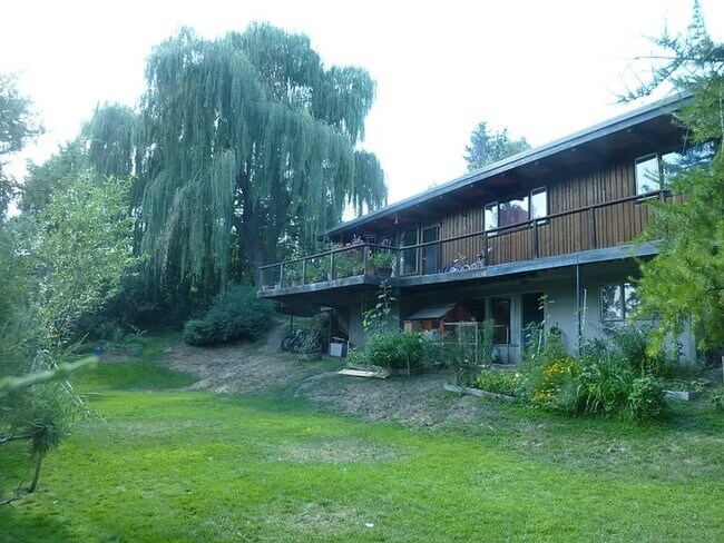 Spacious yard with deck that wraps around house. Walkout daylight basement. - 1705 NE Lower Dr