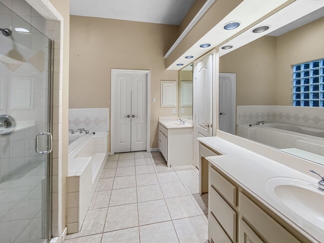 Spacious primary bathroom with separate shower, double vanities, make up area, and jetted tub. - 1314 Creekwood Dr
