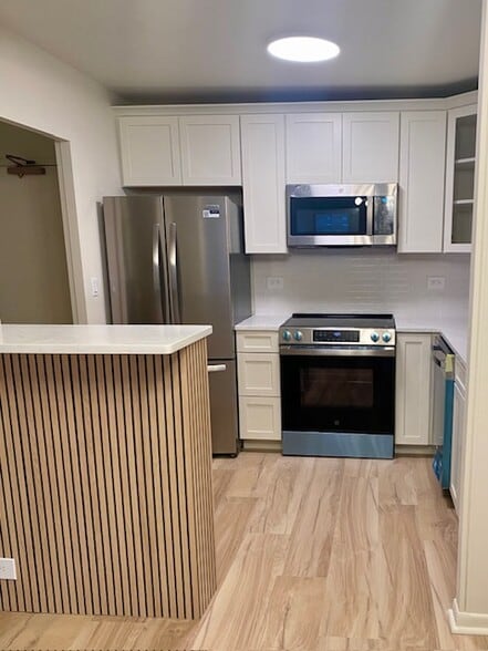 New stainless kitchen with quartz breakfast bar/island - 1850 N Clark St