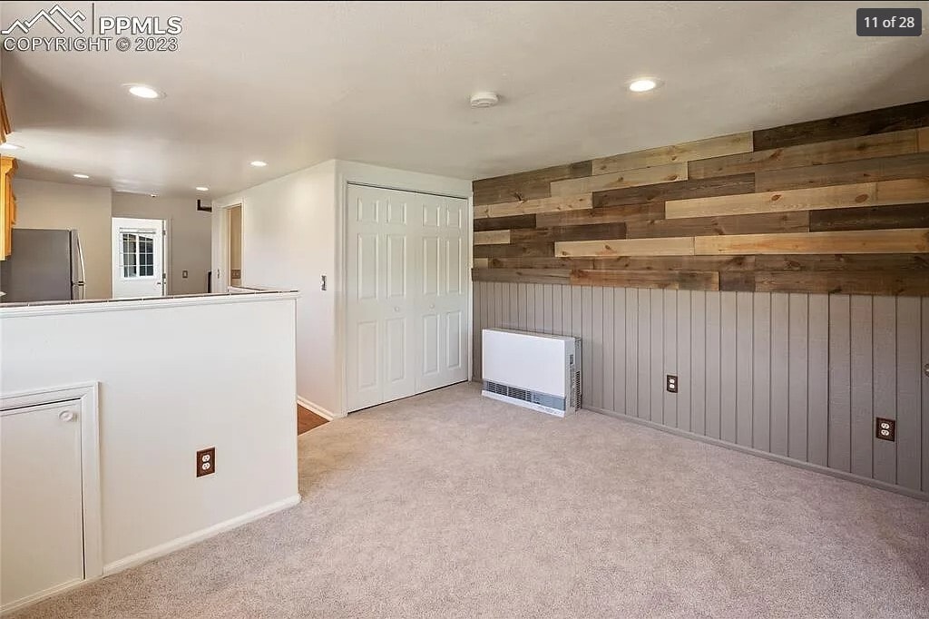 Living Room with Wall Furnace and showing the Laundry Area (Behind folding doors) - 206 W Carr Ave
