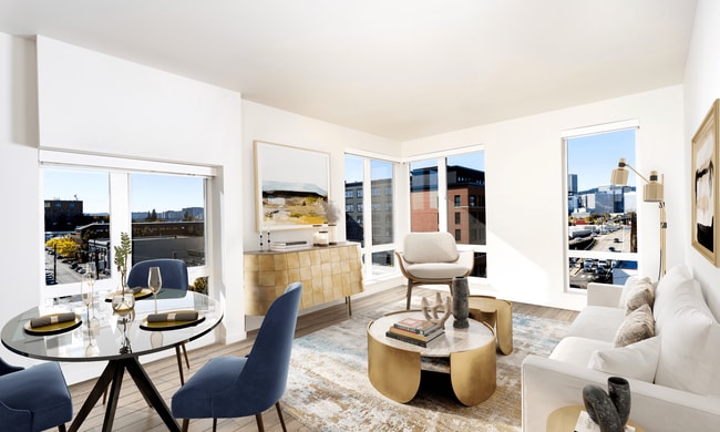 A light-filled living space at Modera Belmont, framed by expansive windows and city views, just steps from Belmonts cafés, boutiques, and local favorites. - Modera Belmont