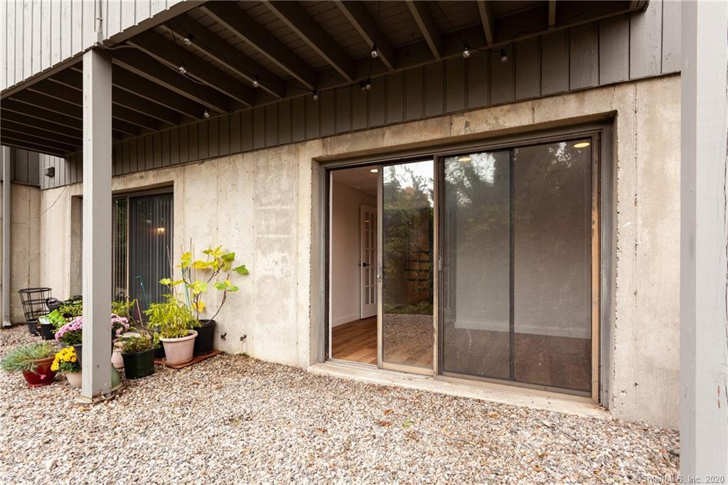 Secluding patio space behind building accessible through glass slider doors - 188 Flax Hill Rd