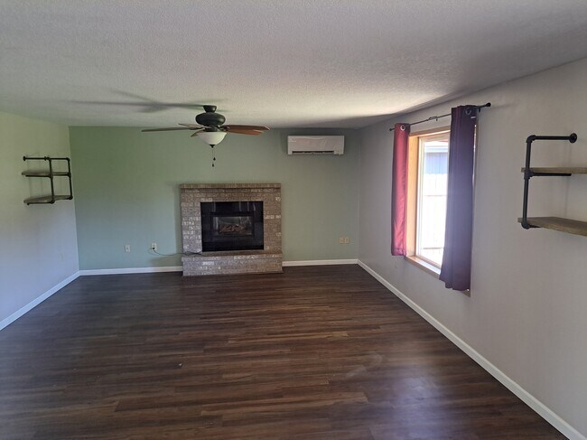 Living room with mounted shelving and fireplace - 15815 NE 69th St