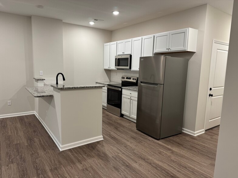 Bright open-concept living with modern kitchen, brand new stainless steel appliances, and island - 205 Cherry Way