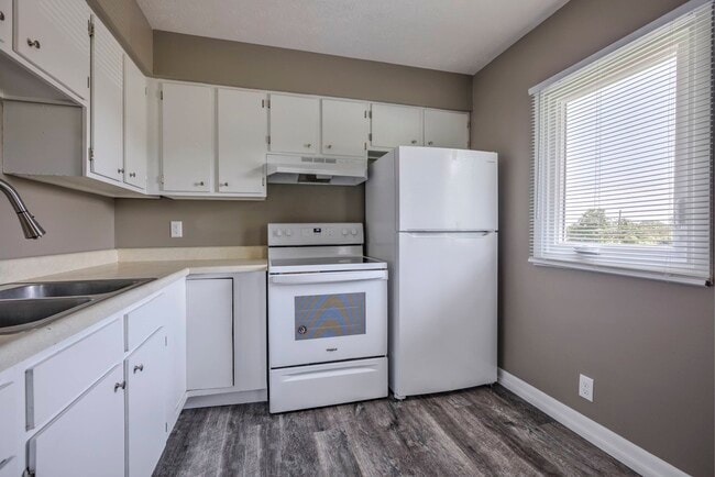 Kitchen with white appliances at Ashland Park Apartments. - Ashland Park II Apartments