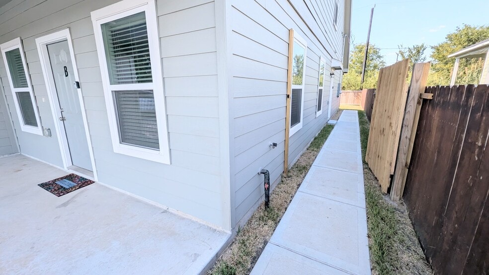 The backyard has sidewalk access from the front porch through a side gate. - 13218 HP Johnson St