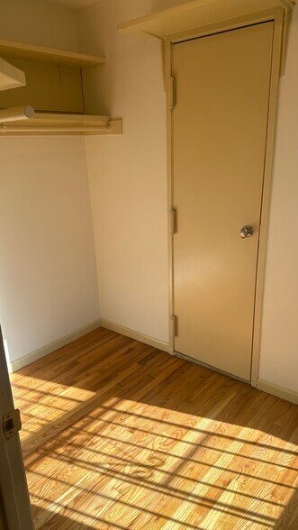 walkin closet with garment racks & utility closet door - 143 Sussex St