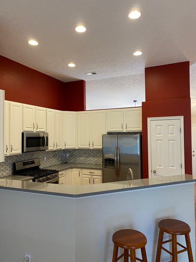 Kitchen quartz countertops and marble backsplash - 709 Warmstone Ct
