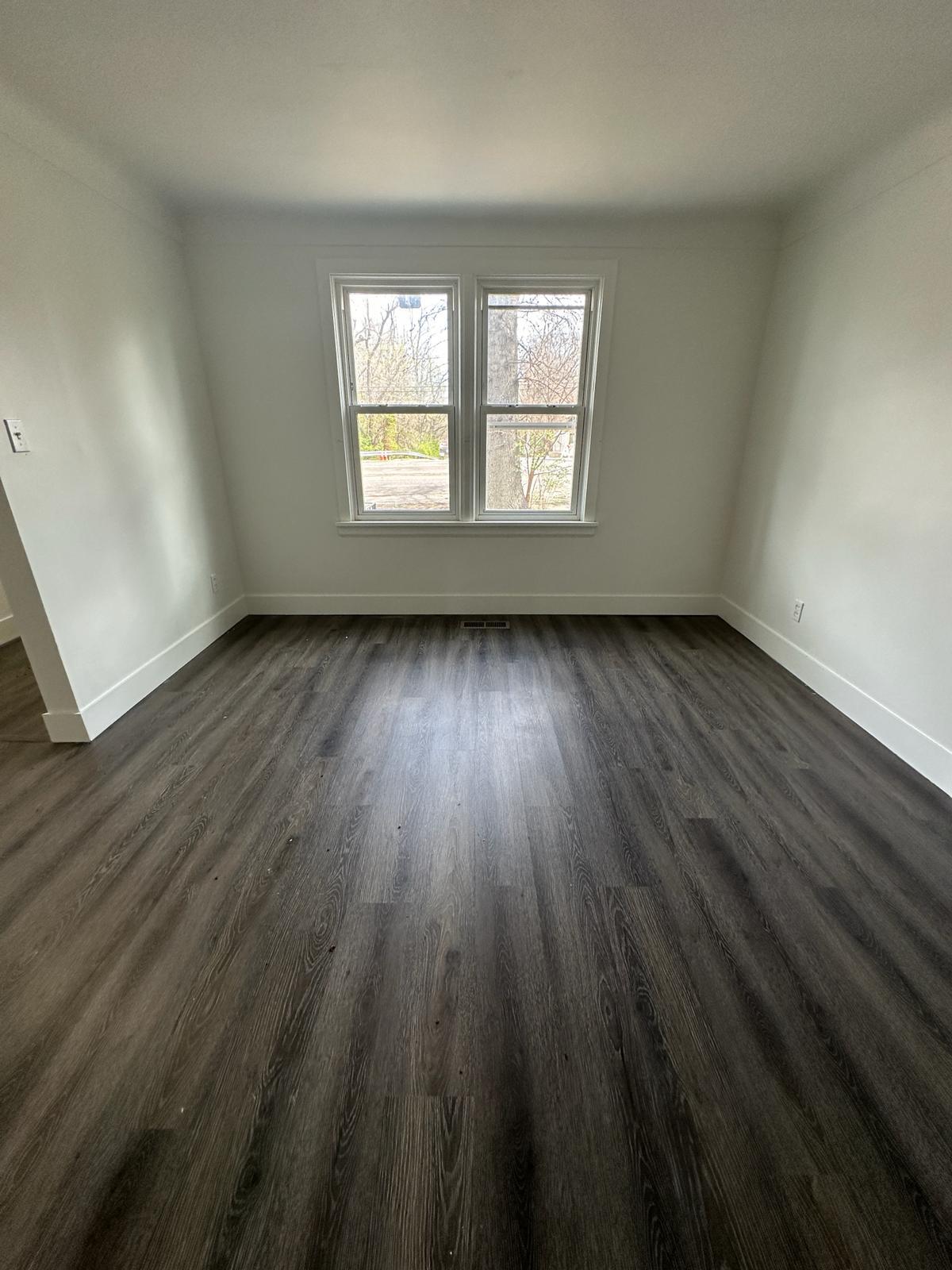 Empty room with dark hardwood / wood-style flooring - 1247 N Florissant Rd
