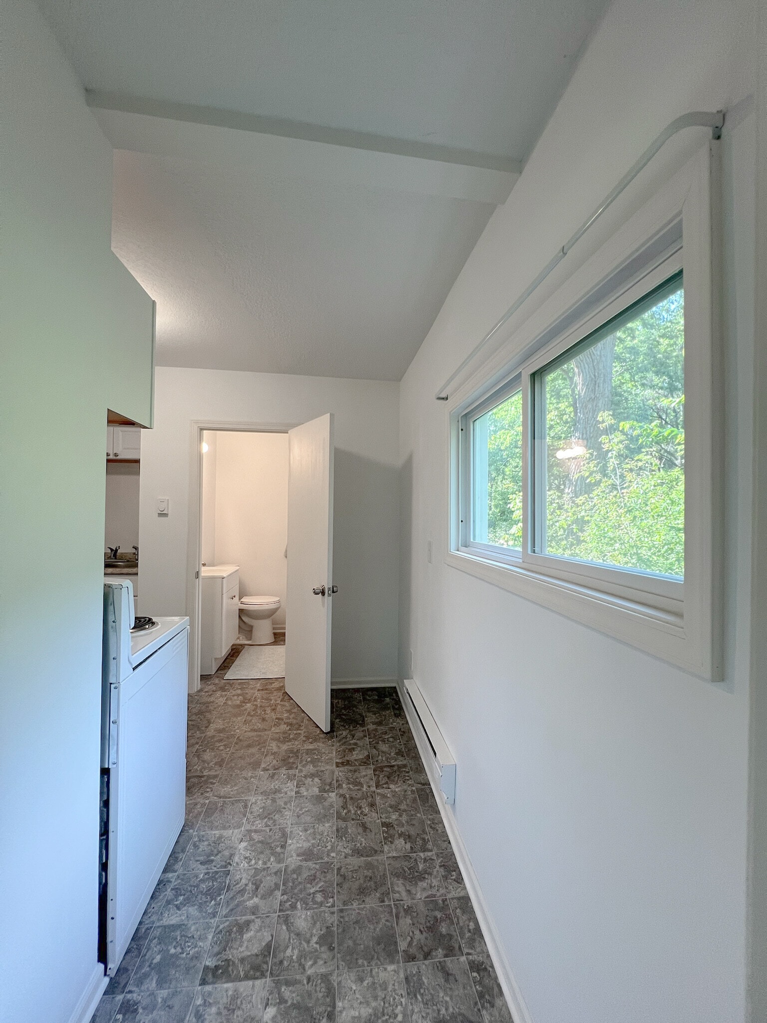 Hall from the bedroom to the kitchen and bathroom. Views to wooded backyard. - 16610 8th St N