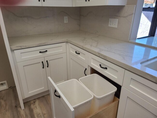 trash pullout in kitchen w/new cabinets/ quartz tops - 673 Arroyo Oaks Dr
