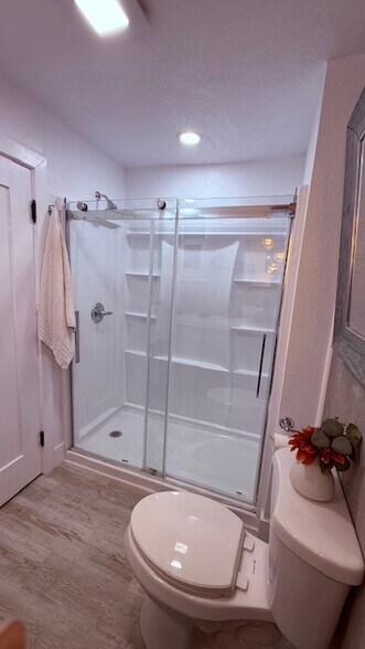 New oversized shower with glass sliders and built-in shelving. - 24606 University Ave