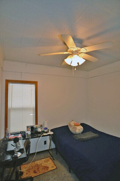 Main floor bedroom with ceiling fan. - 103 Warwick St SE