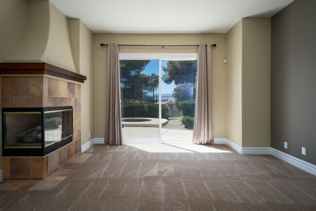 Relax after a long day in this huge primary bedroom with fireplace and sliding doors to the backyard - 2850 Bronzino Ct