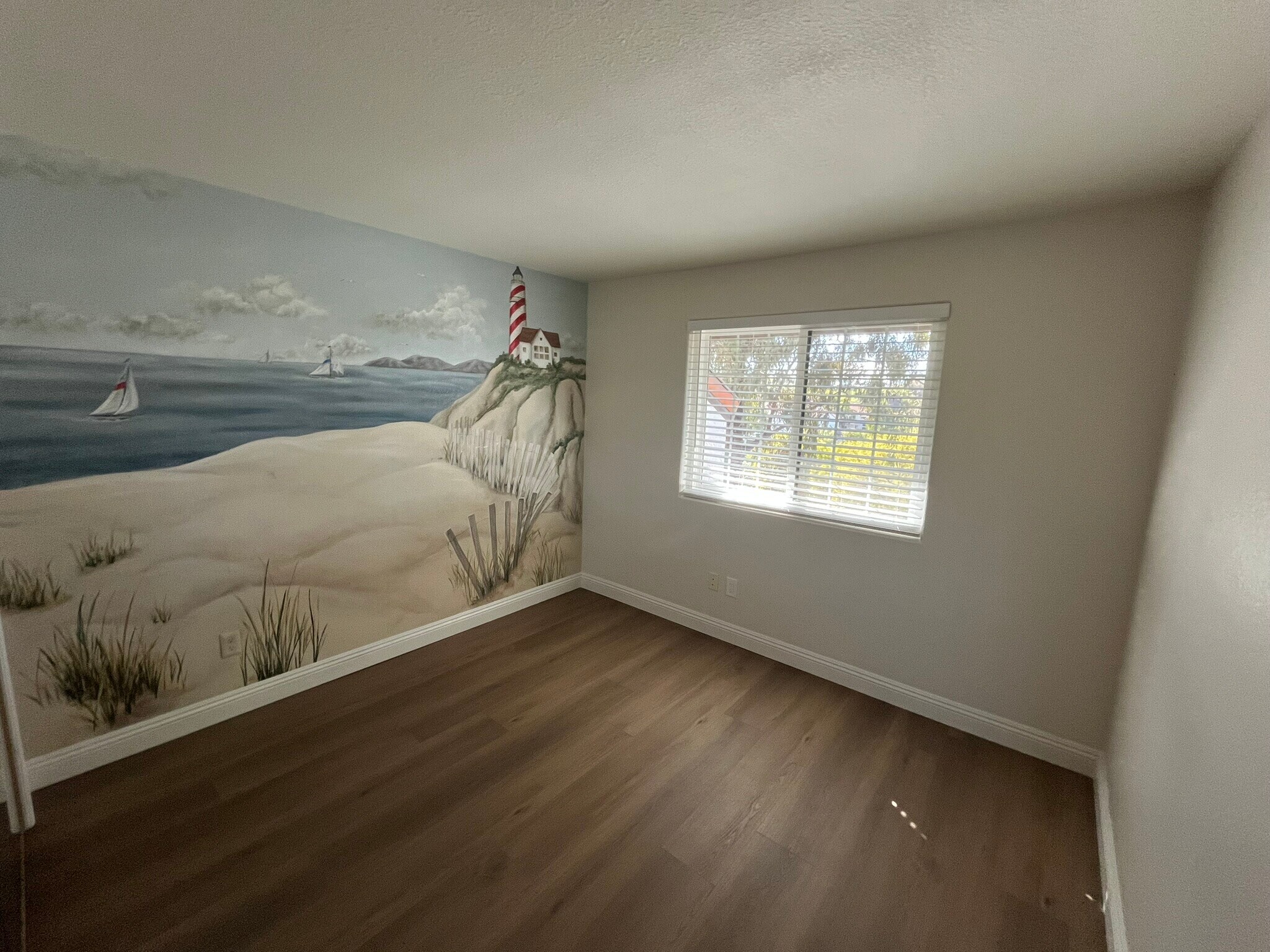 Bedroom with mirrored closet doors with LVP and baseboards in closet - 16274 Avenida Venusto