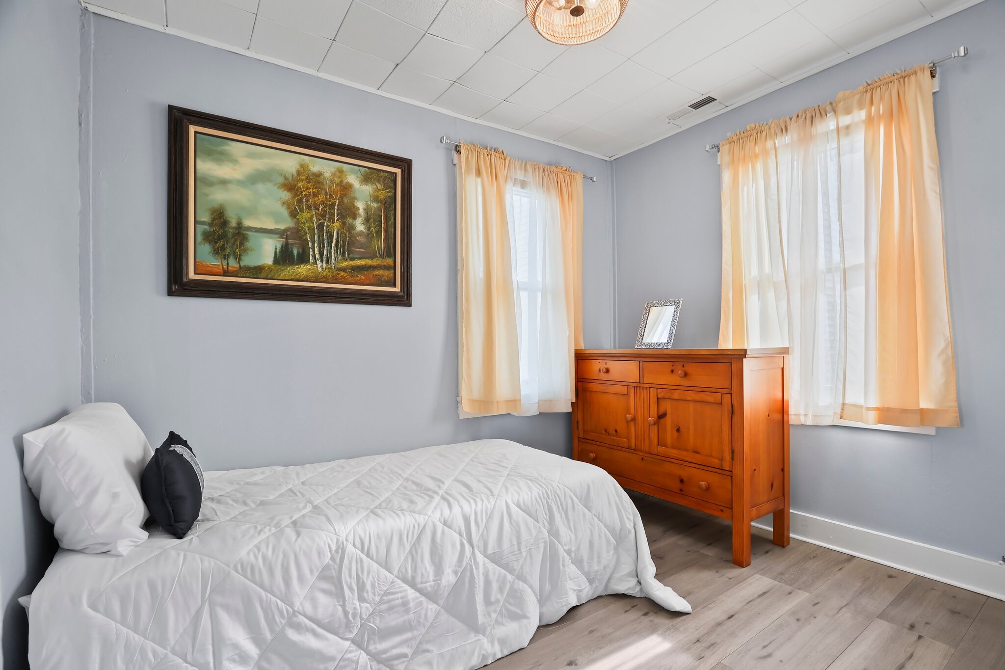 Bedroom with brand-new floors, closet space, beautiful natural light, and dresser - 1710 B St