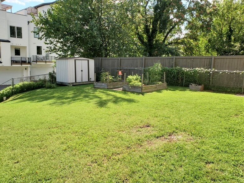 The spacious, fenced in backyard contains to raised beds - perfect for a small vegetable garden. - 1025 Wade Ave