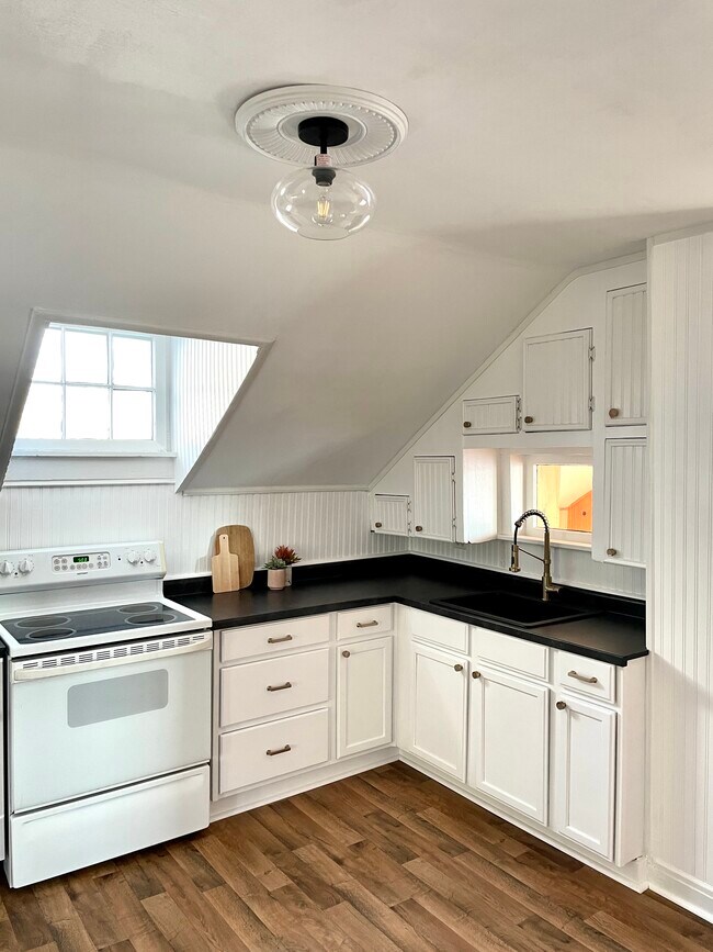 New countertops, fridge, flooring, sink, and fixtures in an efficient eat-in kitchen - 432 Webster St