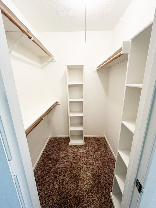 A walk-in closet offering plenty of storage with built-in shelves and hanging space. - 4917 Jamesway Rd