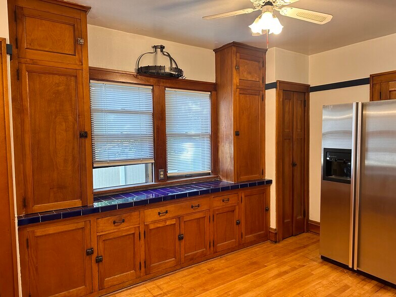 Kitchen with stainless steel side by side refrigerator and pot rack - 7526 Lincoln Pl