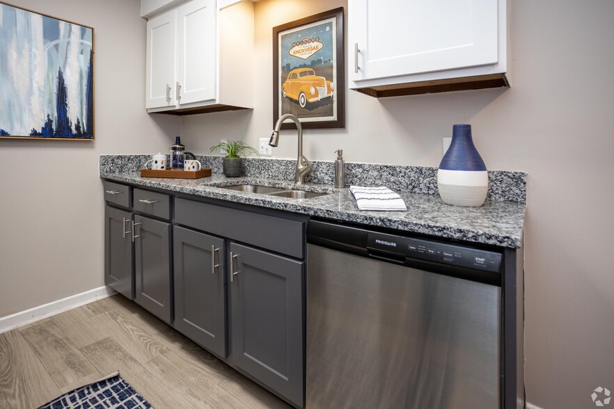 Kitchen with granite counters, stainless appliances, and two-tone modern cabinetry\ - Addison at Sutherland