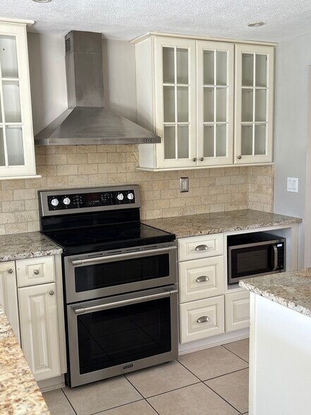 Kitchen is updated with plenty of white cabinetry and stainless appliances. - 4332 S Atlantic Cir