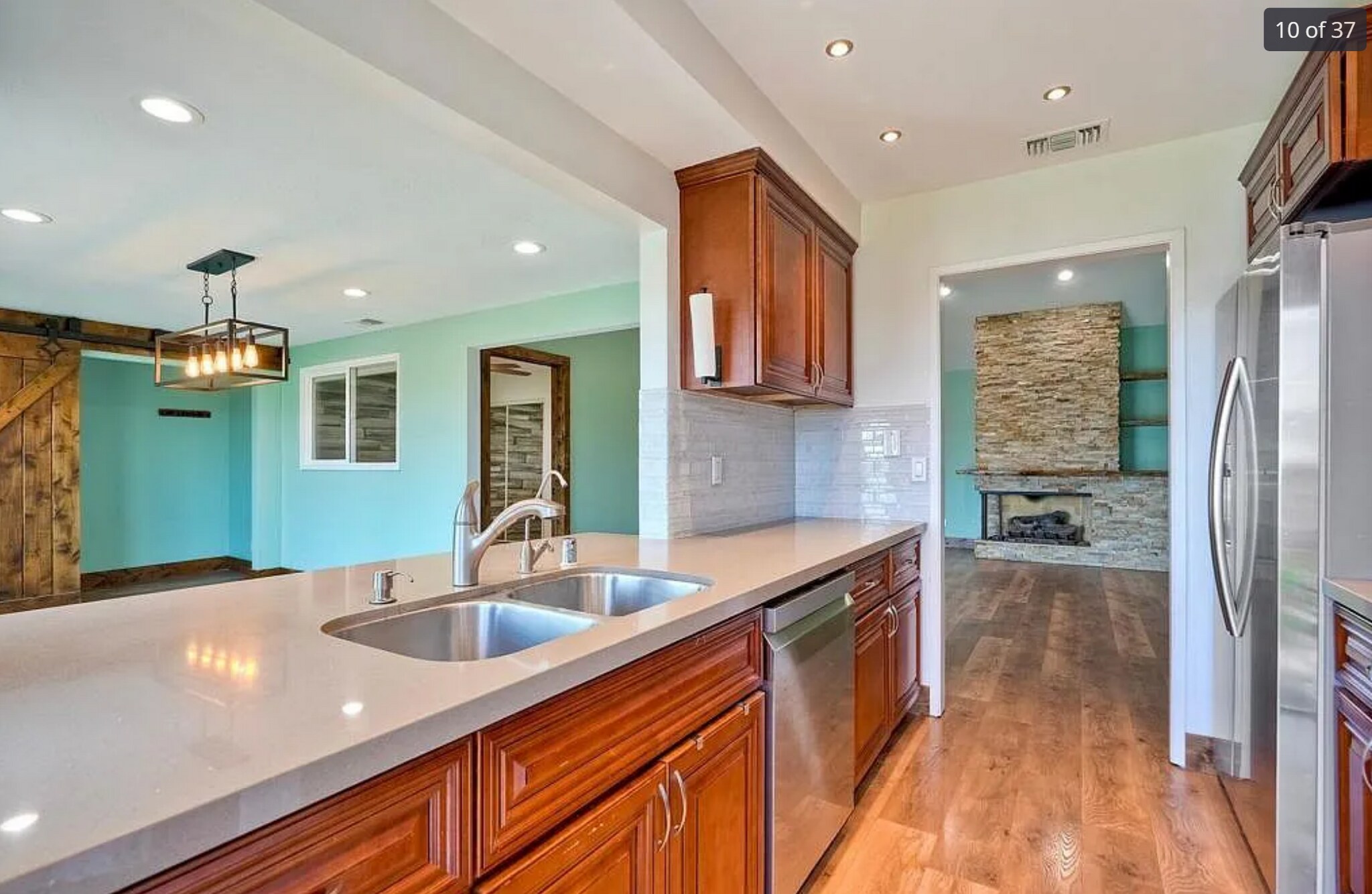 Kitchen with bar, stainless steel appliances, and door to patio - 14787 Caminito Orense Oeste